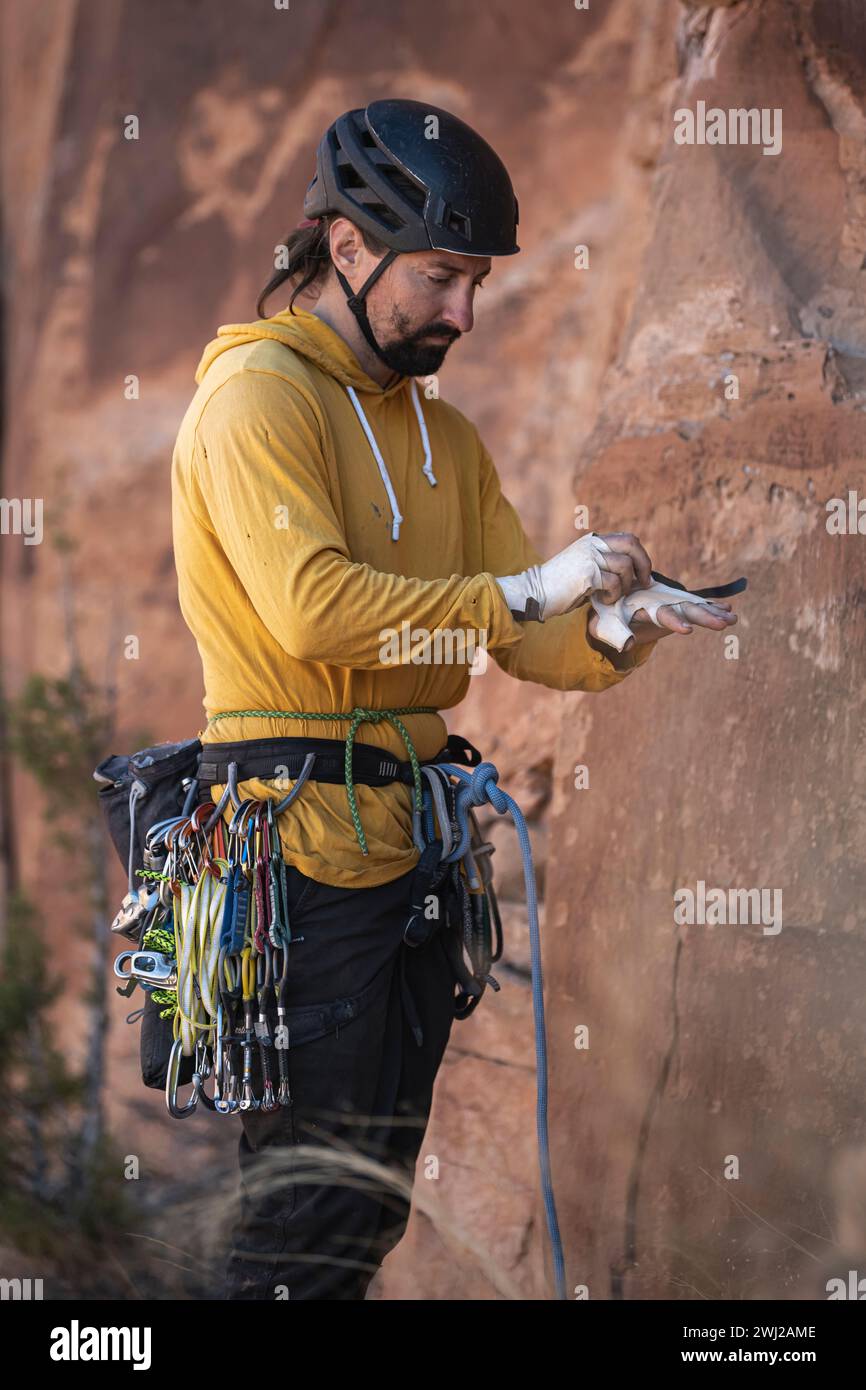 Man wearing tape gloves while standing with climbing equipment Stock Photo