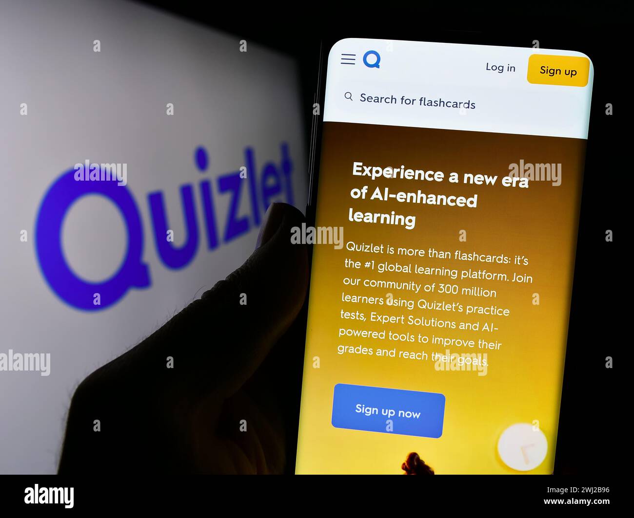 Person holding cellphone with webpage of US online learning company