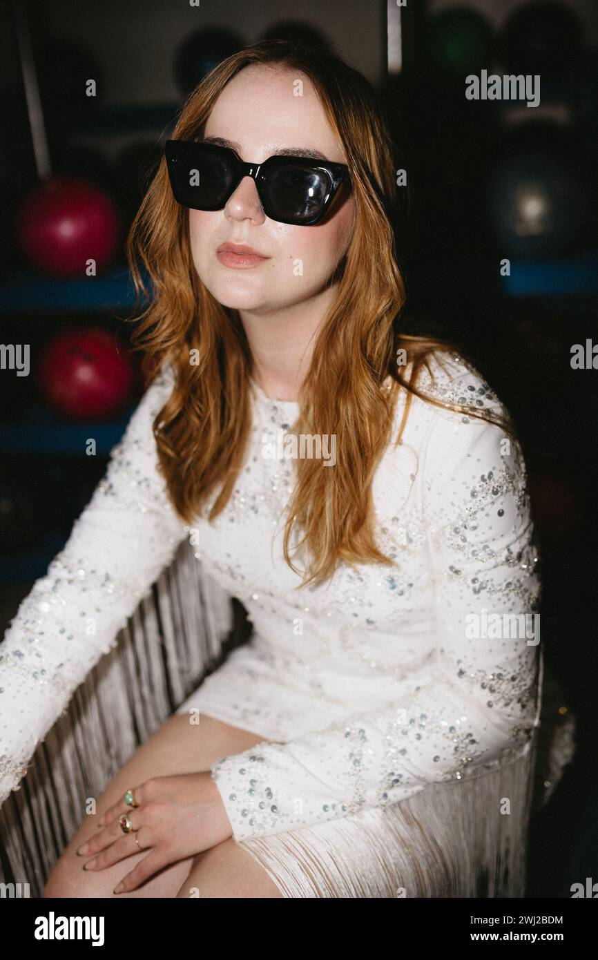 Cool girl in flashy dress and sunglasses at party Stock Photo
