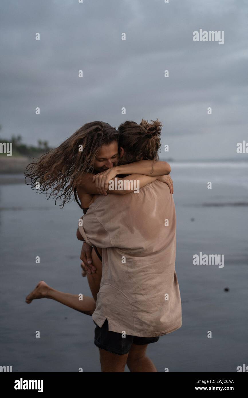 Young cheerful happy couple in love hugging on the beach. Stock Photo