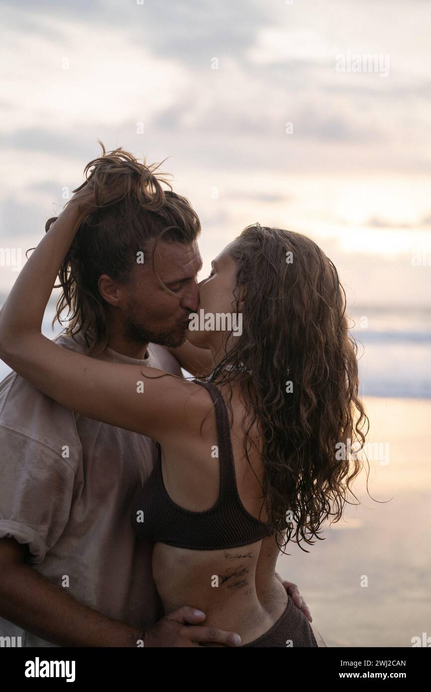 Young cheerful happy couple in love kissing on the beach. Stock Photo