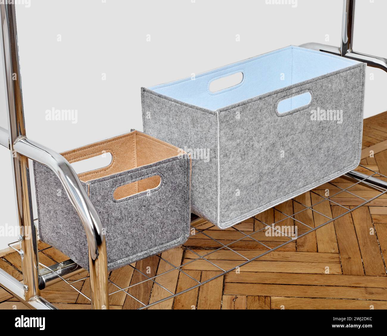 Grey felt storage bins placed on chrome shelving unit over herringbone