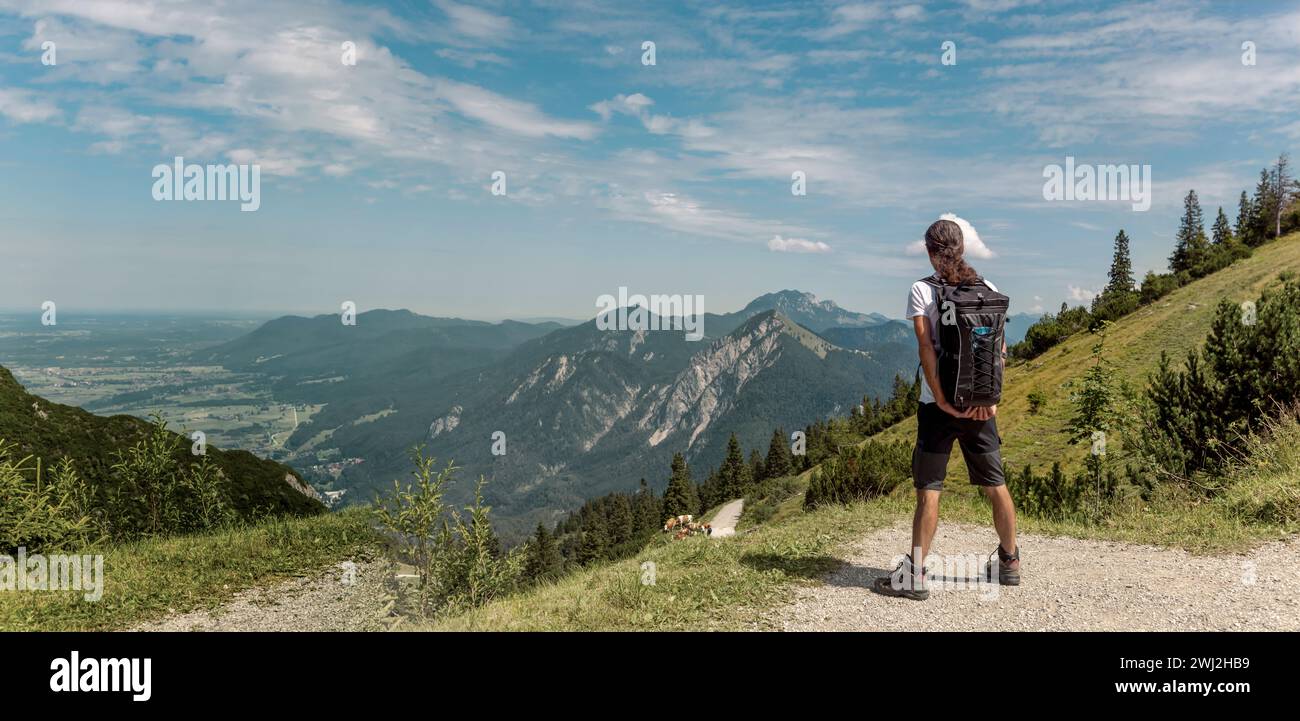 Person in the mountains. Male backpacker looking at the spectacular bavarian mountains. Man hiking Stock Photo