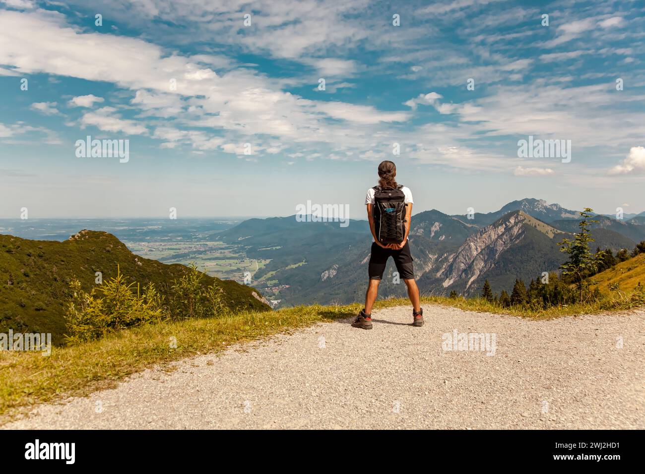 Person in the mountains. Male backpacker looking at the spectacular bavarian mountains. Man hiking Stock Photo