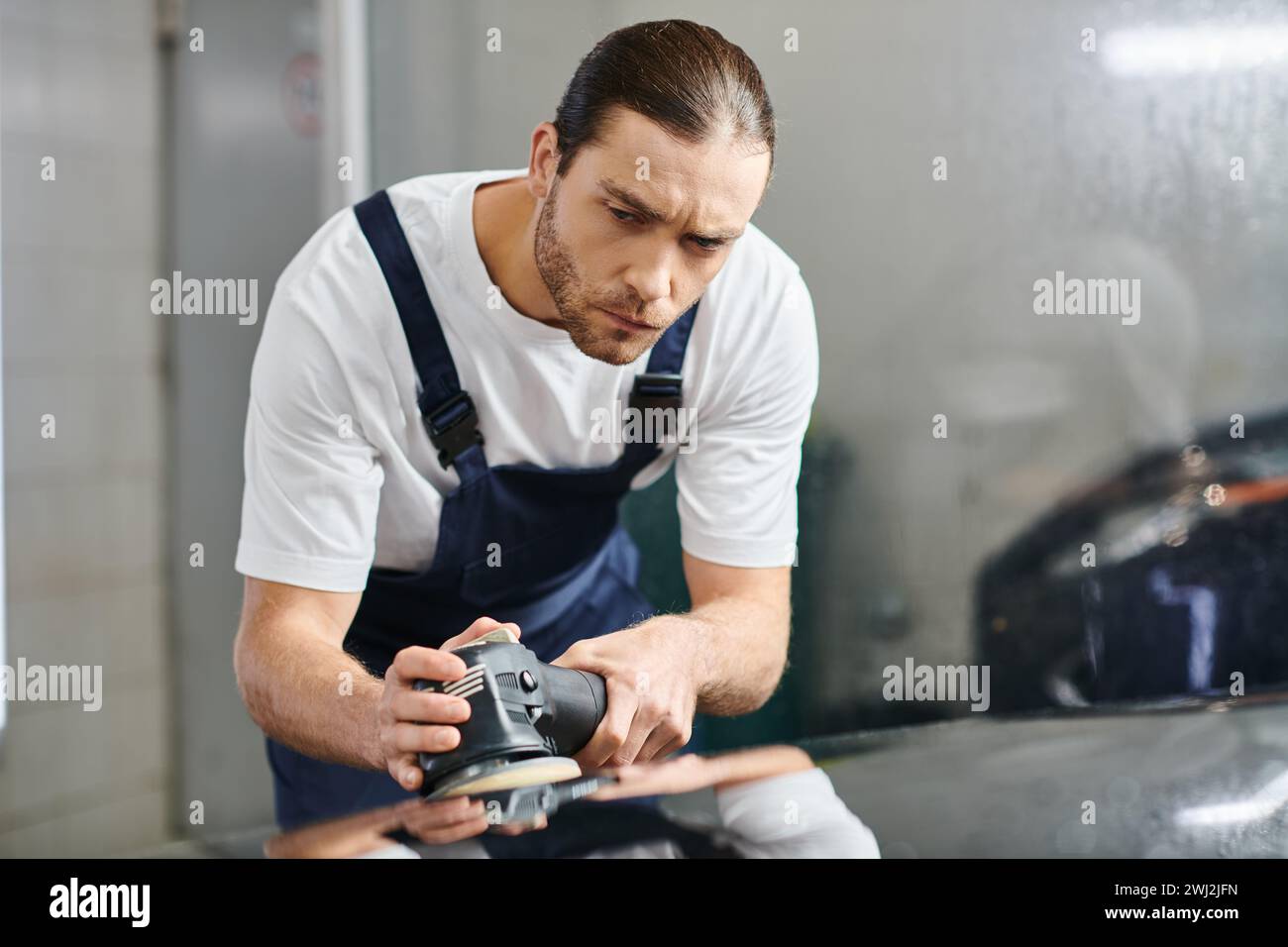 attractive devoted serviceman in uniform with collected hair using polishing machine carefully Stock Photo