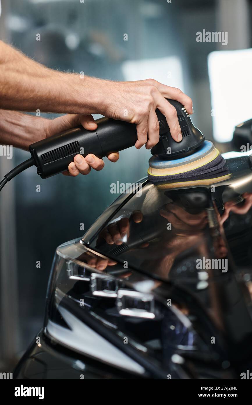 cropped view of dedicated professional serviceman using polishing machine on black modern car Stock Photo