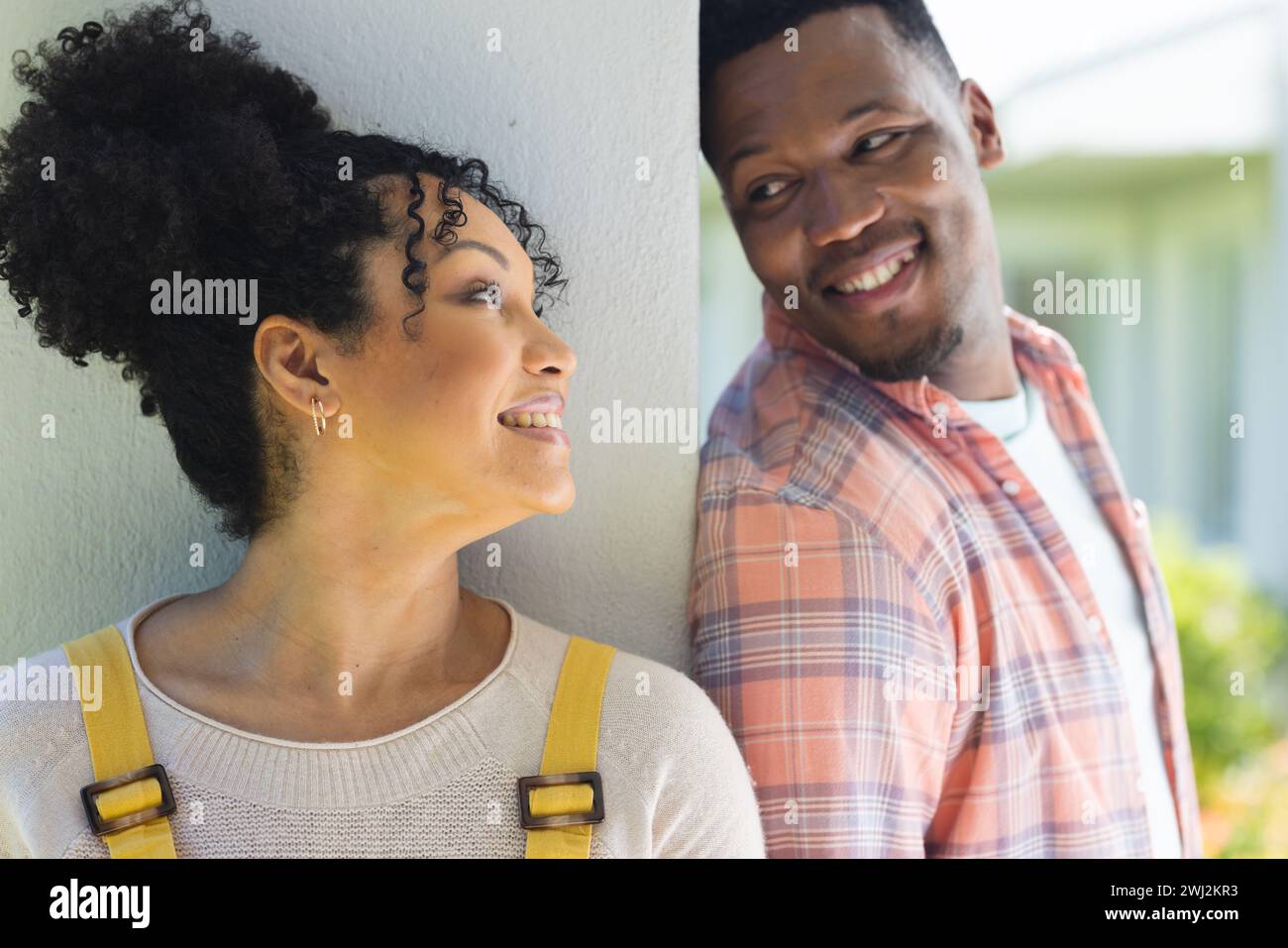 Happy african american couple looking at each other in sunny garden ...