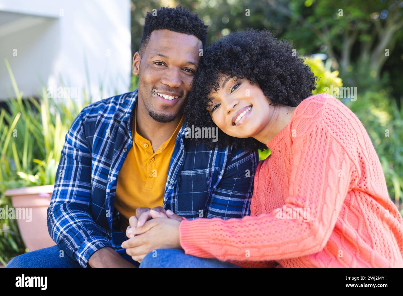 Happy african american couple embracing and holding hands on stairs in ...
