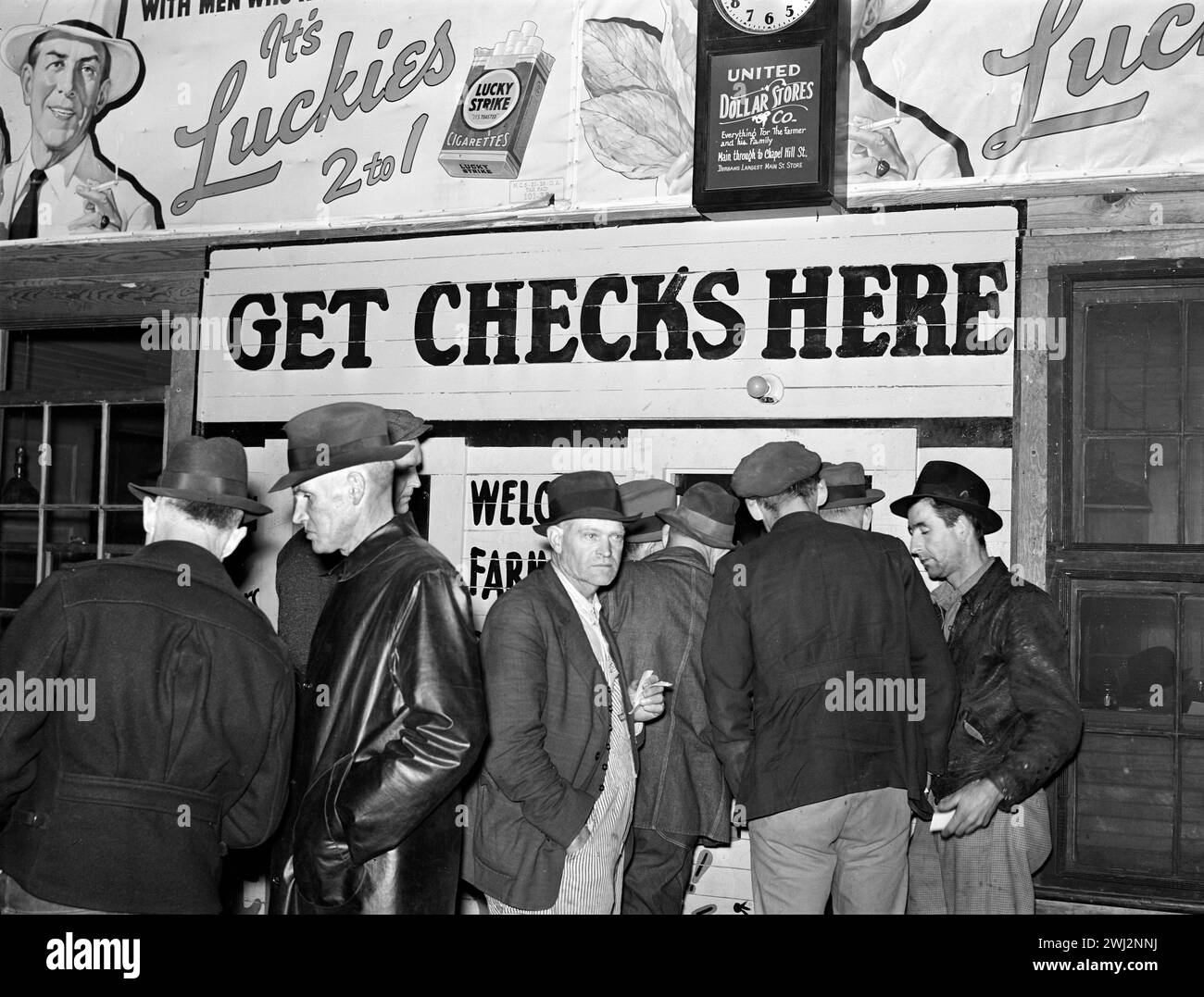 Farmers in warehouse getting their checks after tobacco auction sale, Durham, North Carolina, USA, Marion Post Wolcott, U.S. Farm Security Administration, November 1939 Stock Photo