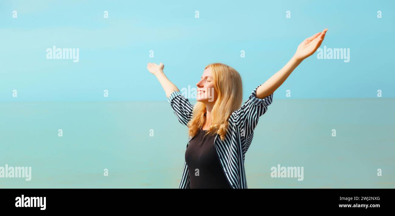 Summer vacation, happy young woman raising her hands up on the beach on ...