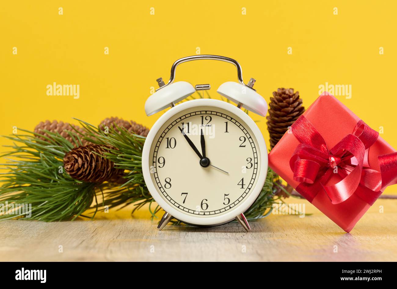 Alarm clock and stack of red gift boxes on yellow background Stock Photo