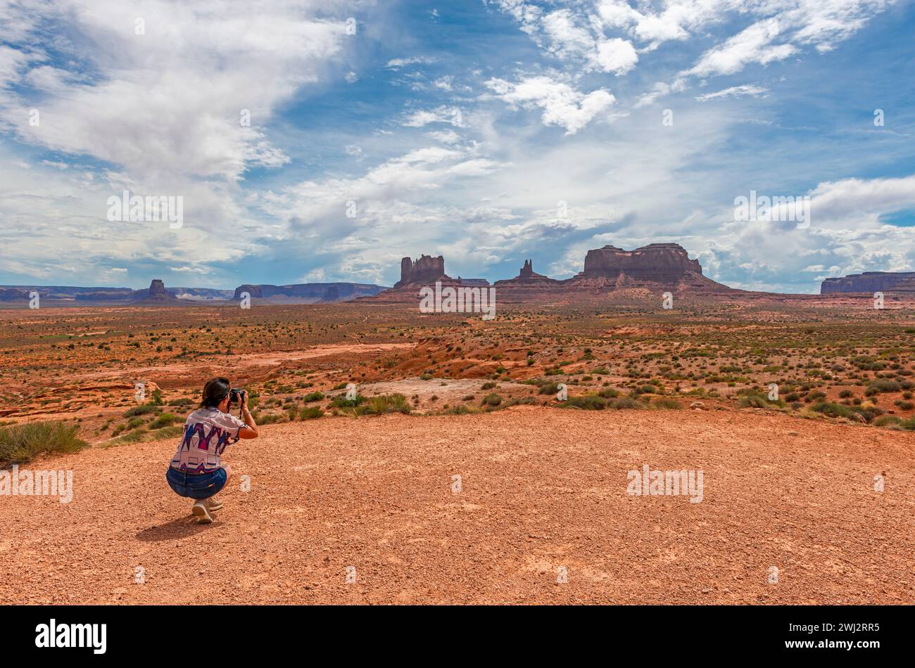 Woman tourist taking photographs of the buttes of the Monument Valley Navajo Tribal Park, Arizona and Utah, USA. Stock Photo