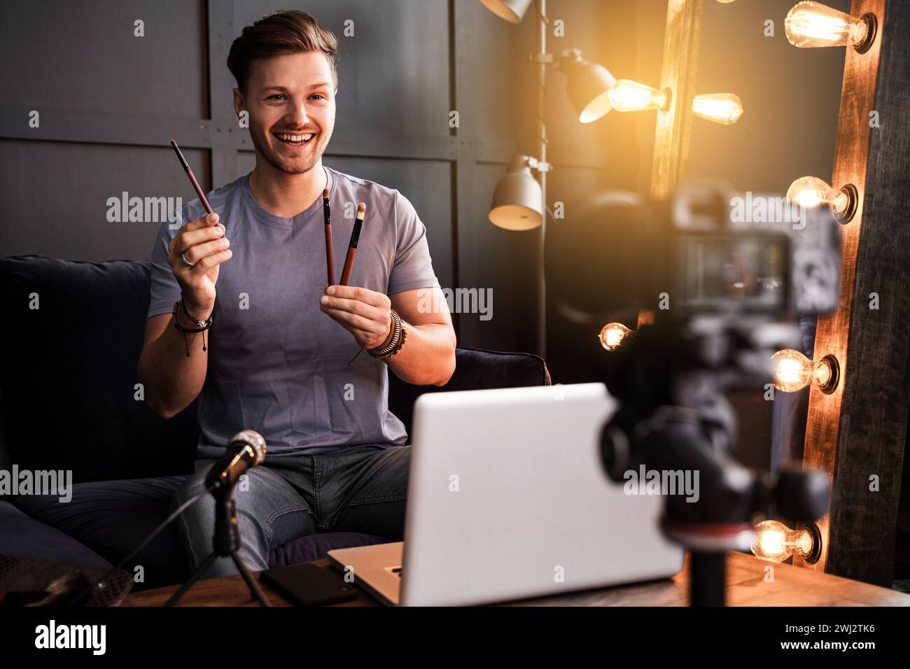 Young smiling blogger is showing makeup brushes Stock Photo