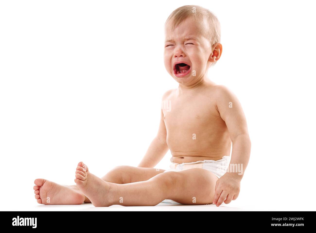 Upset little boy in diaper sitting and crying. Stock Photo