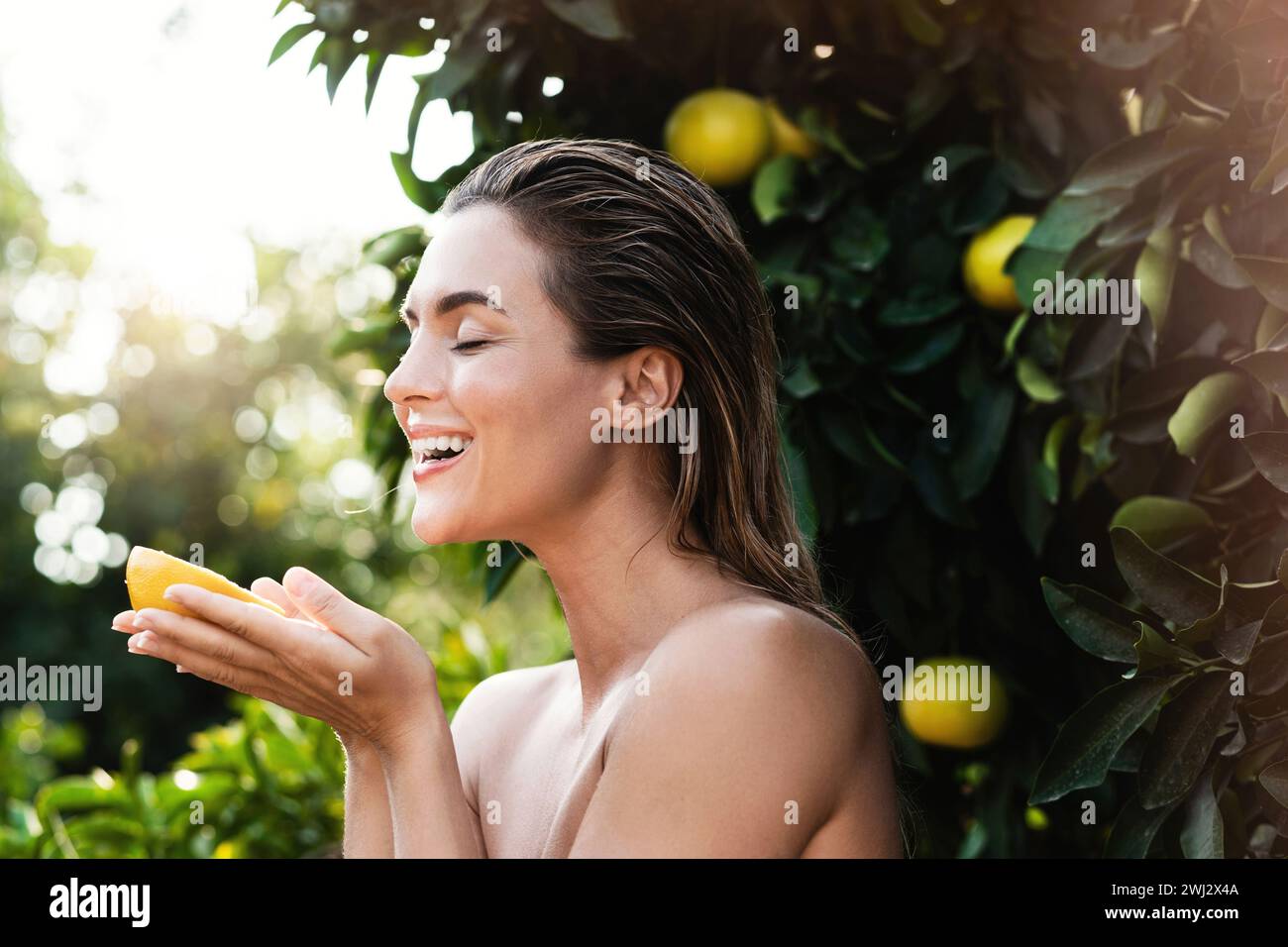Beautiful woman with smooth skin with a lemon fruit in her hands Stock Photo