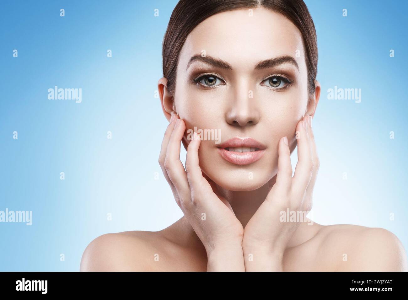 Young woman with natural makeup and smooth skin against light blue background Stock Photo