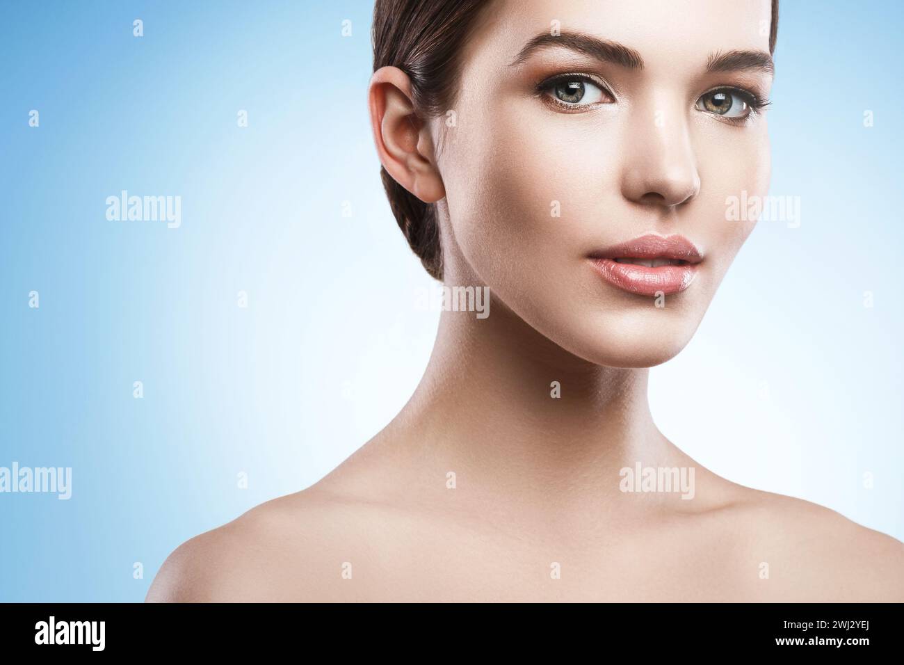 Young woman with natural makeup and smooth skin against light blue background Stock Photo