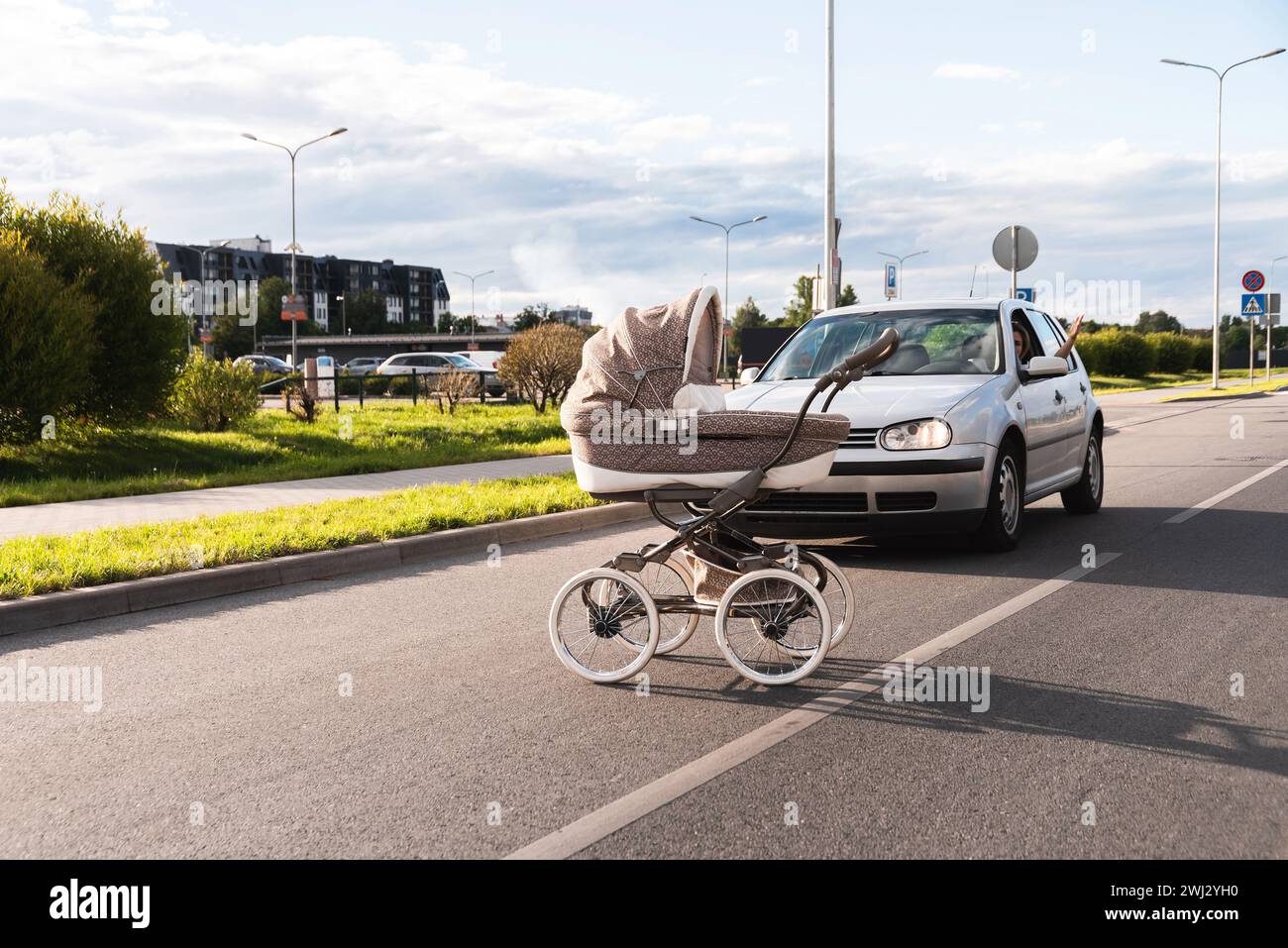 Outraged driver and baby pram rolled out in the middle of the road Stock Photo