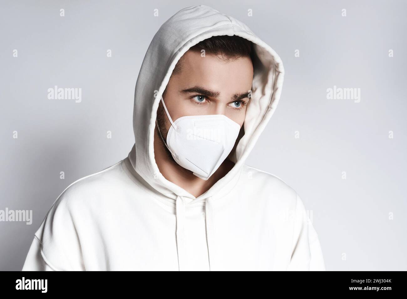 Young man wearing white hoodie and ffp2 respirator mask Stock Photo - Alamy