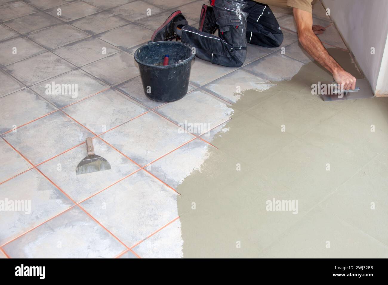 Construction worker leveling compound with putty knife. Renovation ...