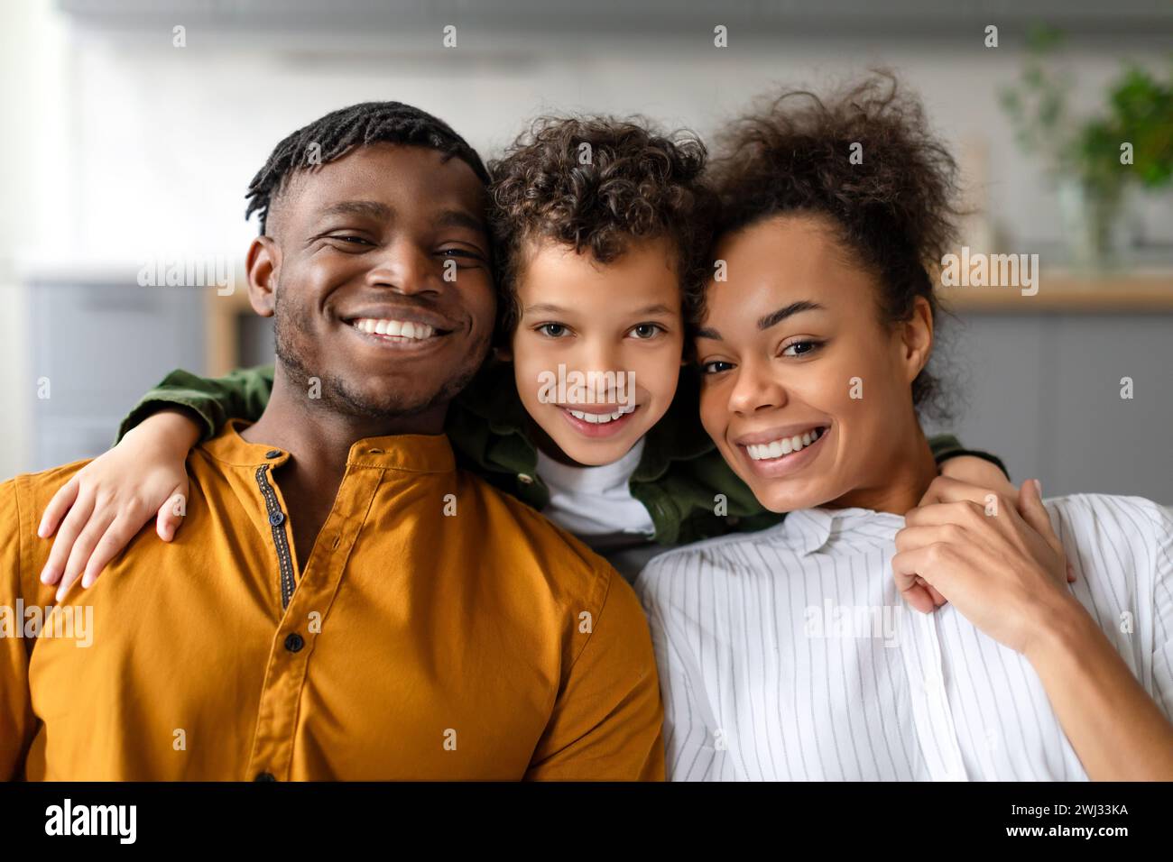 Portrait of cheerful black family of three embracing and smiling Stock ...