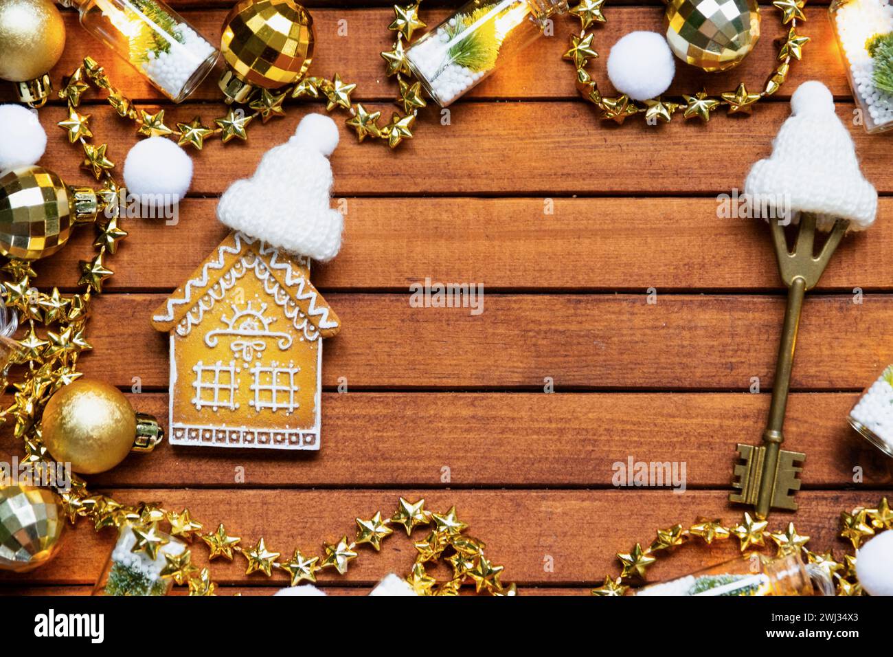 Key to house with a keychain tiny home on wooden background with Christmas decor layout. Gift for New Year, Christmas. Building, Stock Photo