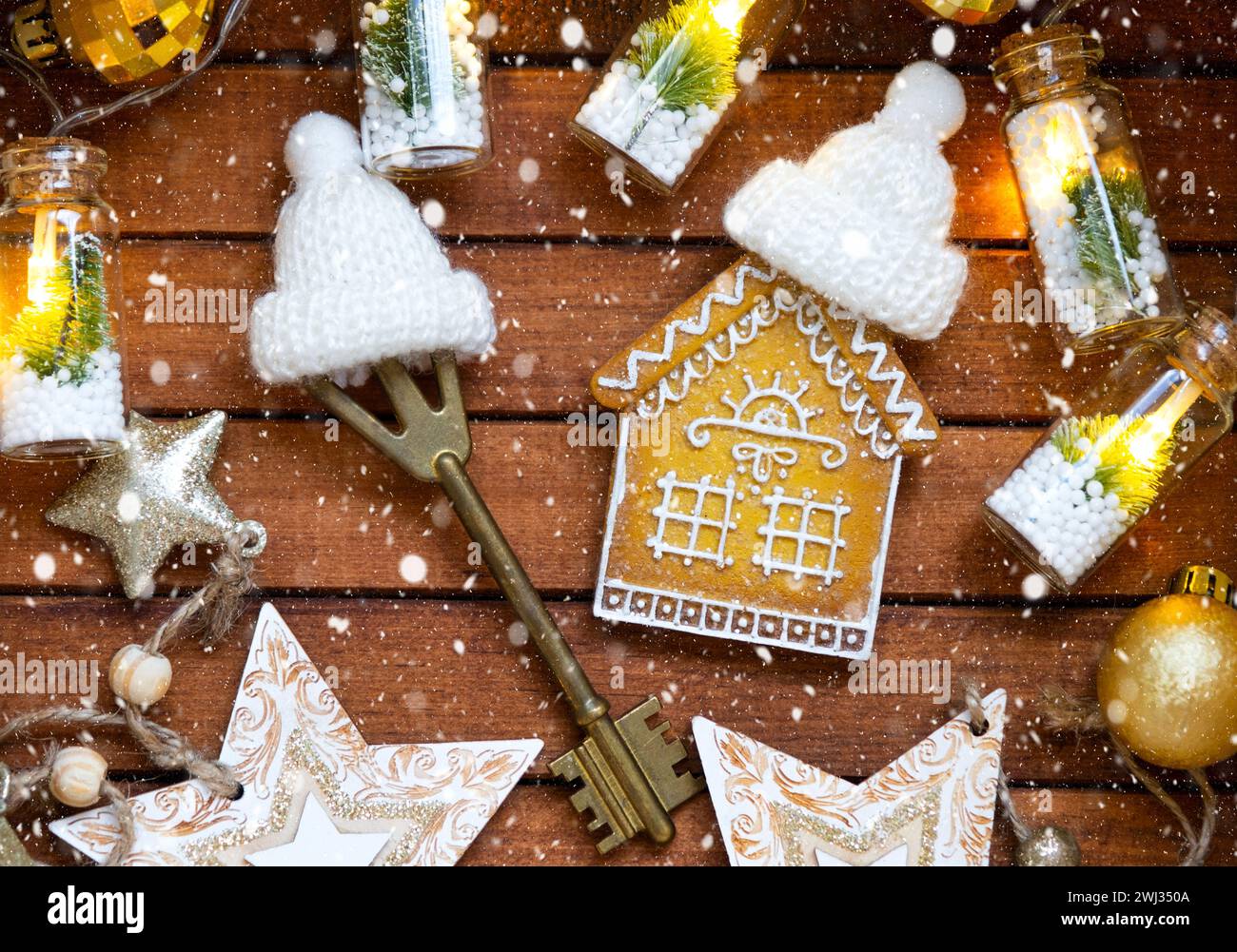 Key to house with a keychain tiny home on wooden background with Christmas decor layout. Gift for New Year, Christmas. Building, Stock Photo