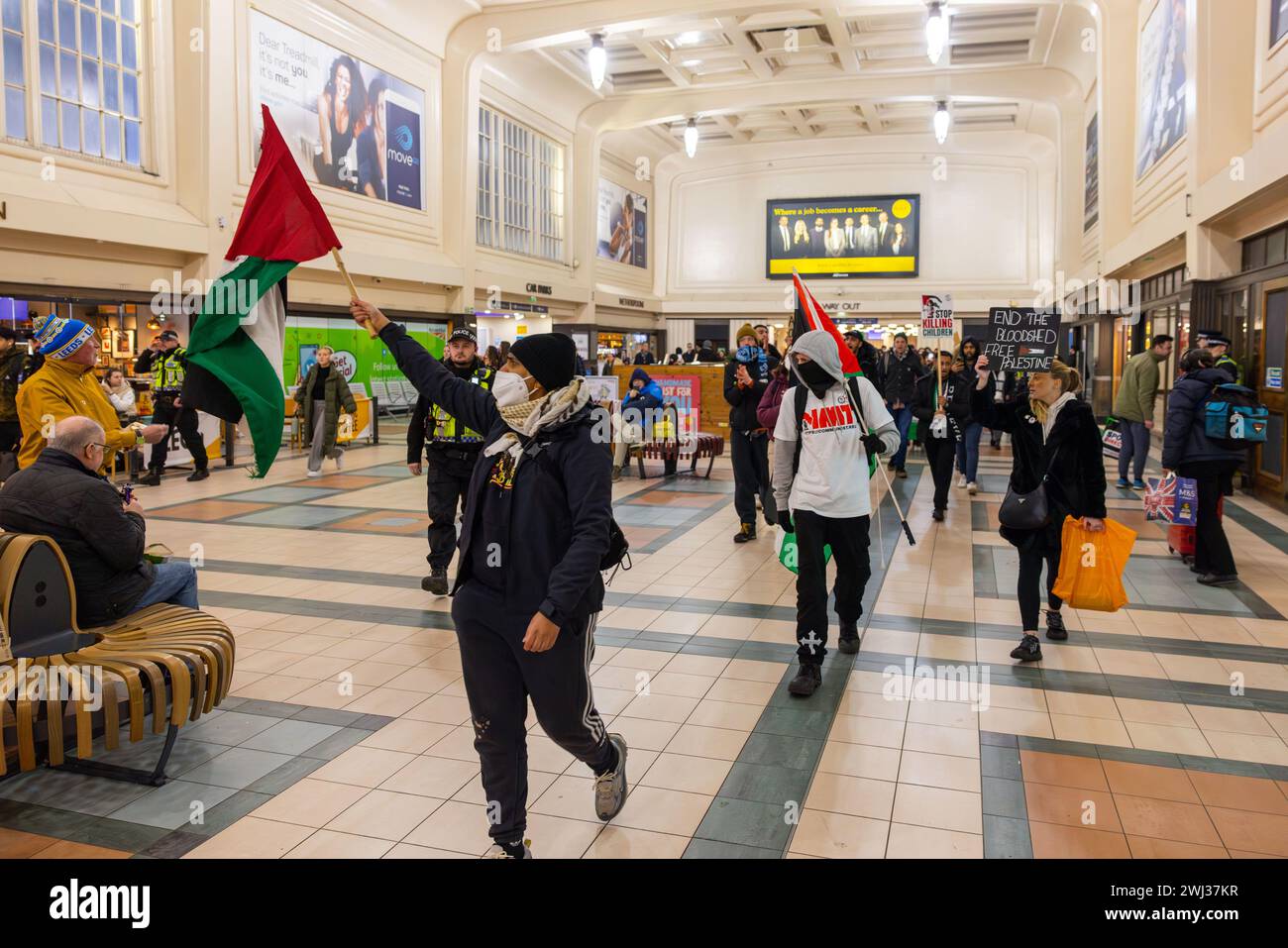 Leeds, UK. 12 FEB, 2024. Pro Palestine demonstrators march through Leeds Station waving flags and banners. Credit Milo Chandler/Alamy Live News Stock Photo