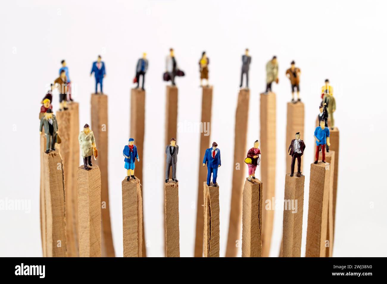 A circle of miniature toy people on wooden blocks keeping distance in public. Social distancing due Stock Photo