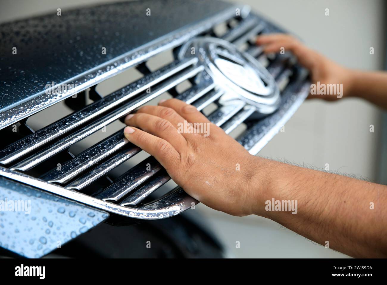 Closeup of a mechanic in a garage closing the hood of car Stock Photo