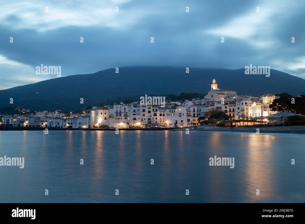 The Cadaques town in Catalonia by sea at dusk with mountains in background Stock Photo