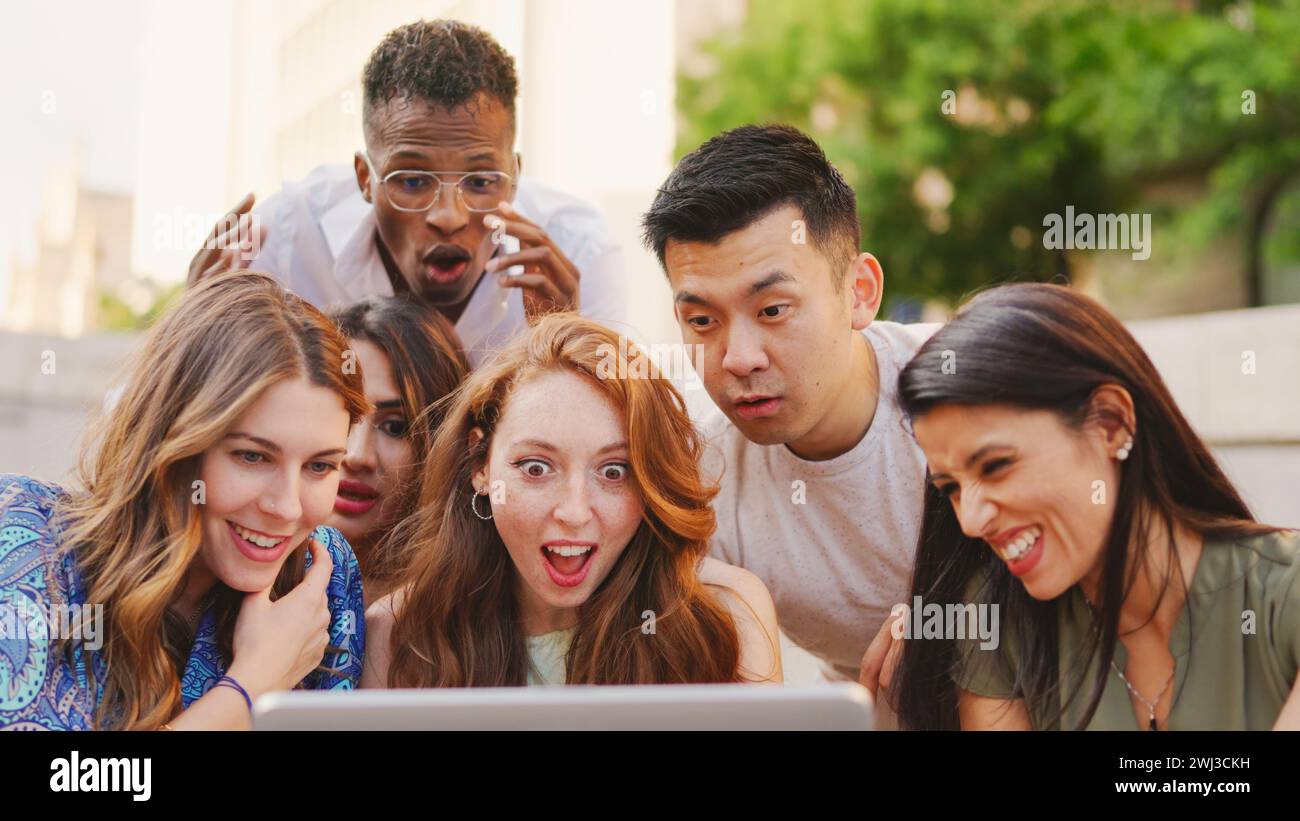Multiethnic group of people looking at a laptop with surprised expression Stock Photo