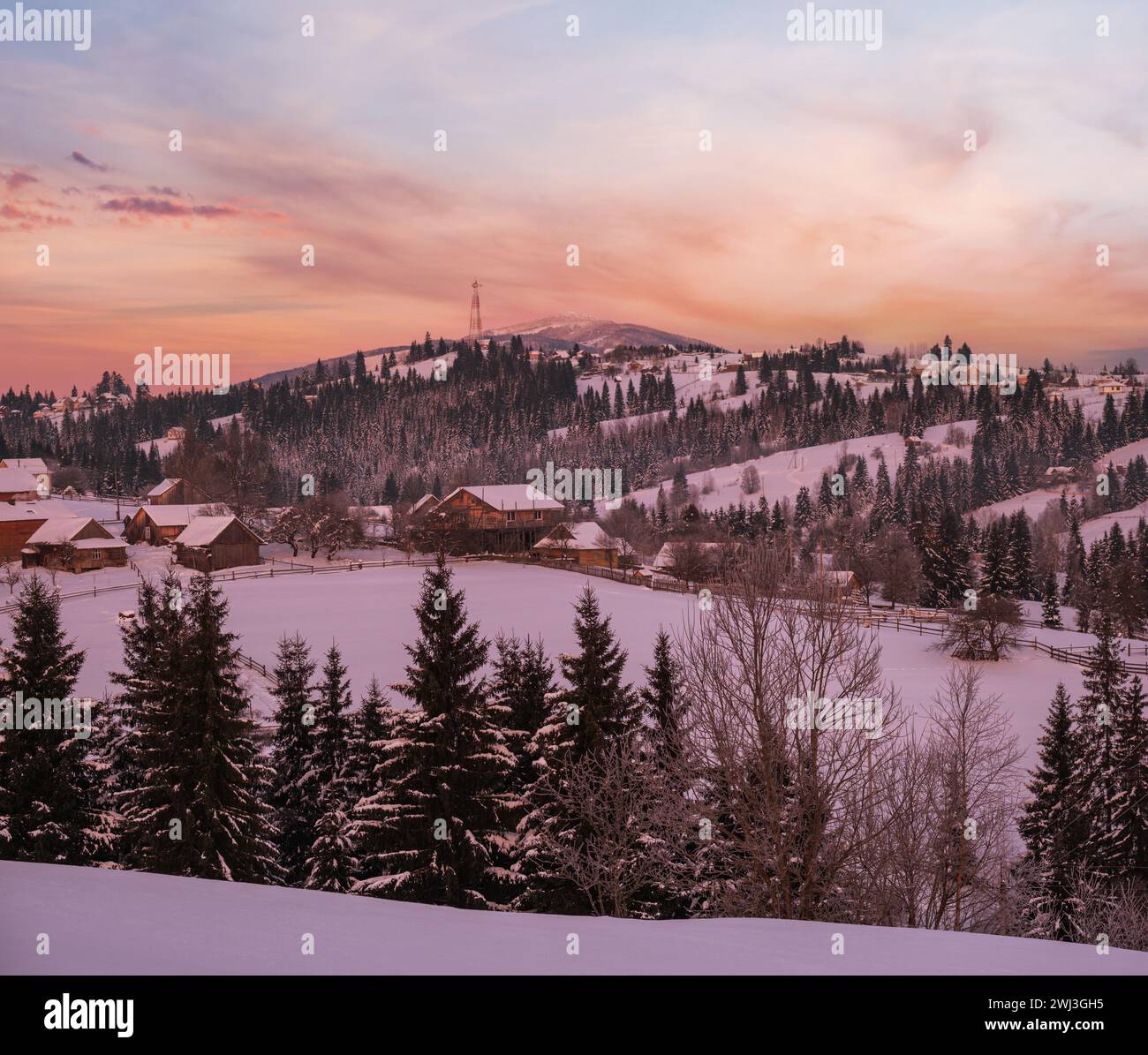 Small and quiet alpine village and winter sunrise snowy mountains around, Voronenko, Carpathian, Ukraine. Stock Photo
