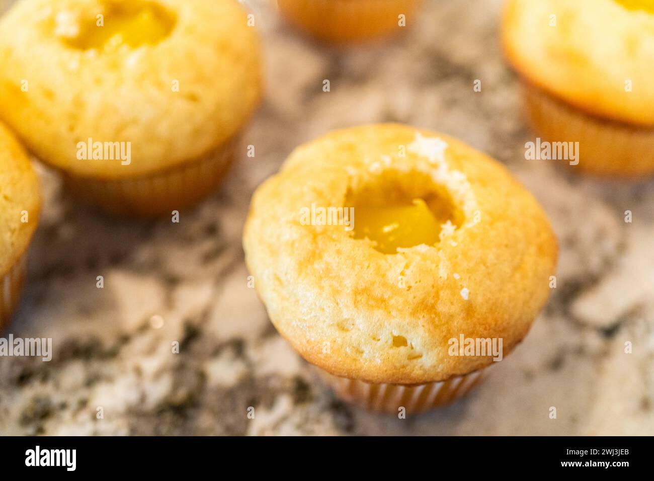 Filling Vanilla, Chocolate Cupcakes with Lemon, Raspberry Stock Photo