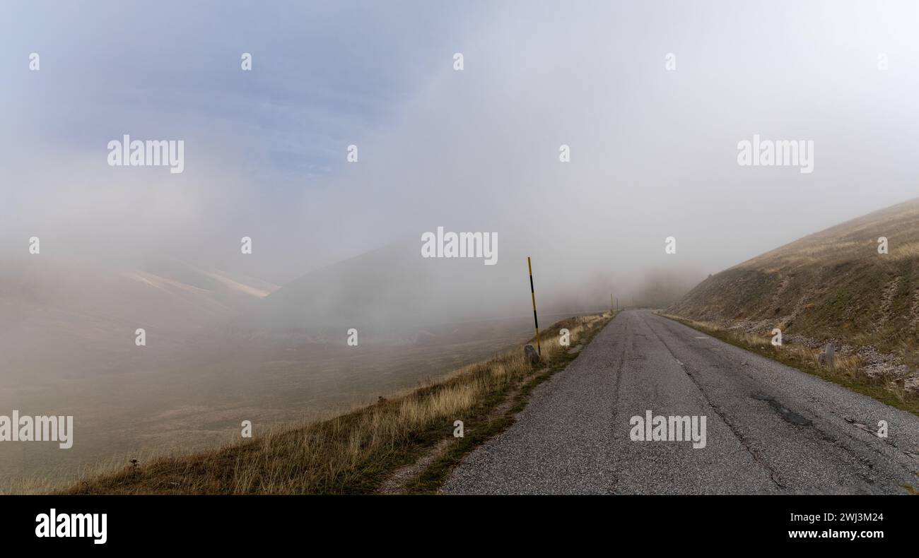 Mountain road leading into thick fog in the Gran Sasso and Monti della Laga National Park Stock Photo