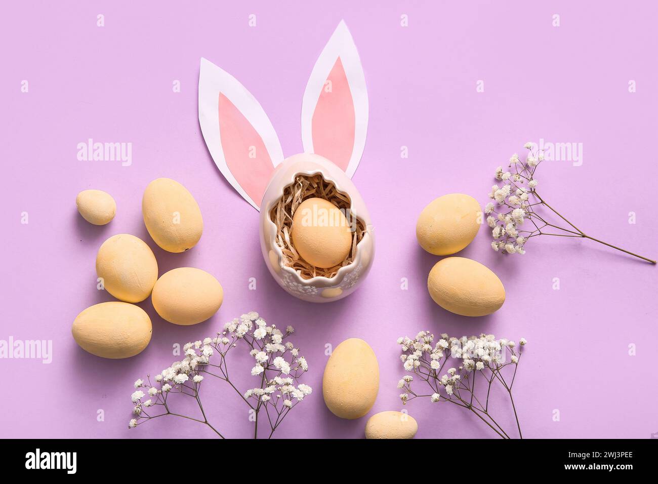 Painted Easter eggs with gypsophila flowers and paper bunny ears on ...
