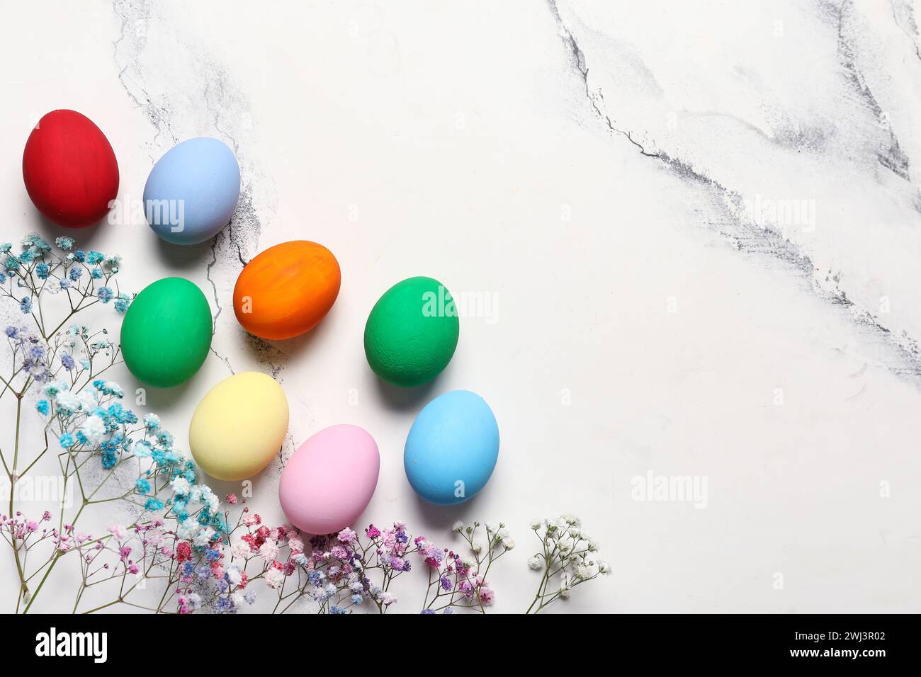 Composition with different painted Easter eggs and gypsophila flowers ...