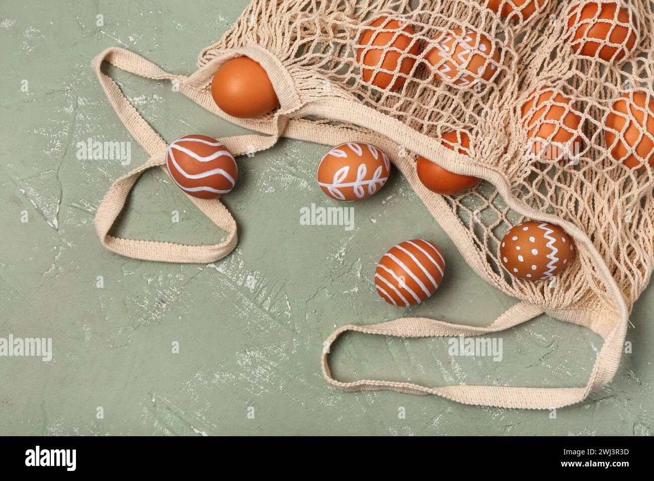 String bag with painted Easter eggs on grey background Stock Photo