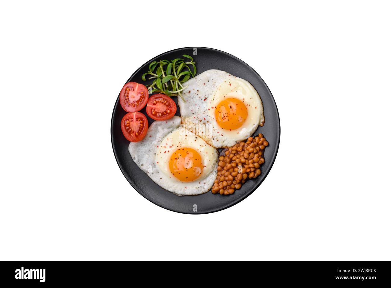 Delicious hearty breakfast consisting of two fried eggs, canned lentils and microgreens Stock Photo