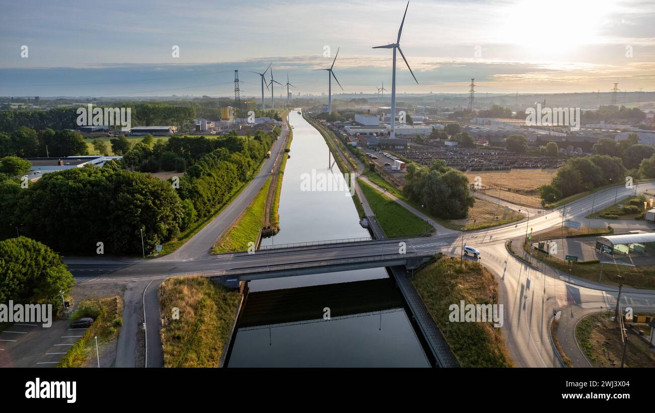 Eco-Friendly Dawn: Wind Turbines Along the Canal Stock Photo