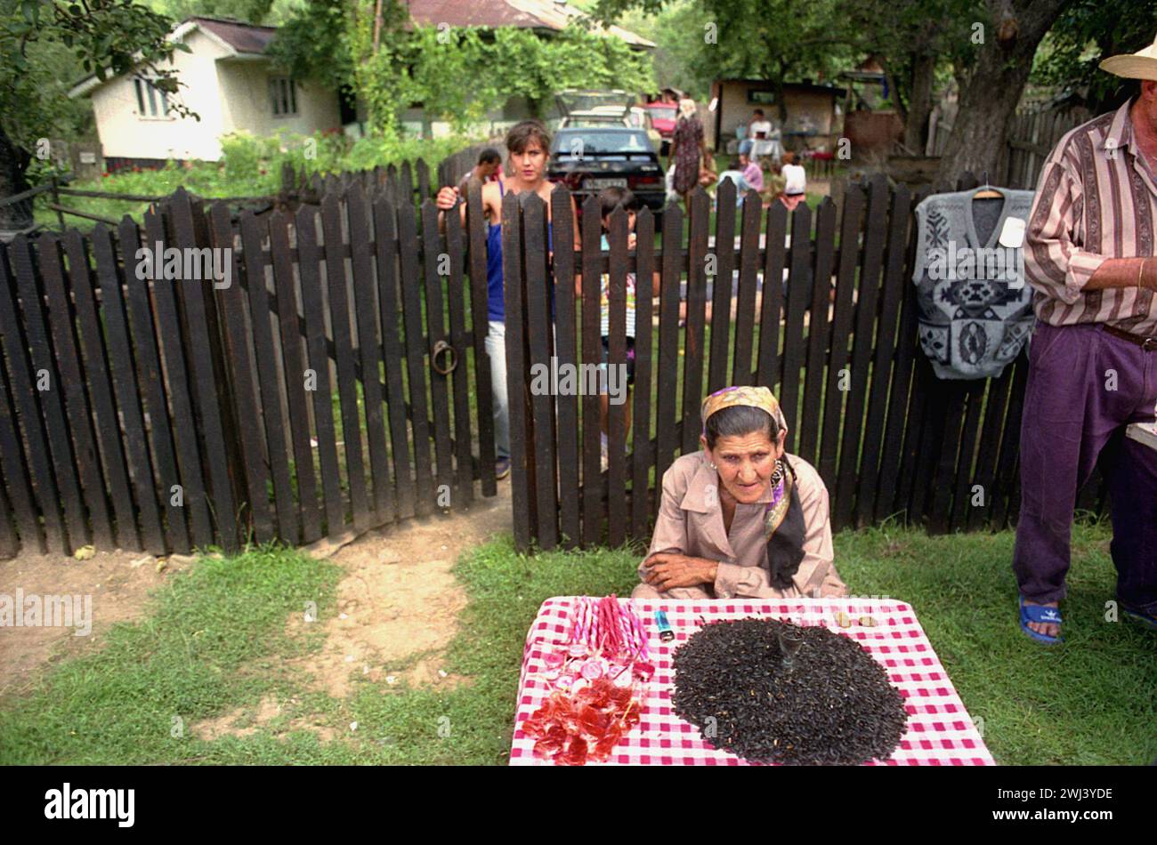 Vrancea County, Romania, approx. 1998. Elderly woman selling sunflower seeds and candies at a country fair. Stock Photo