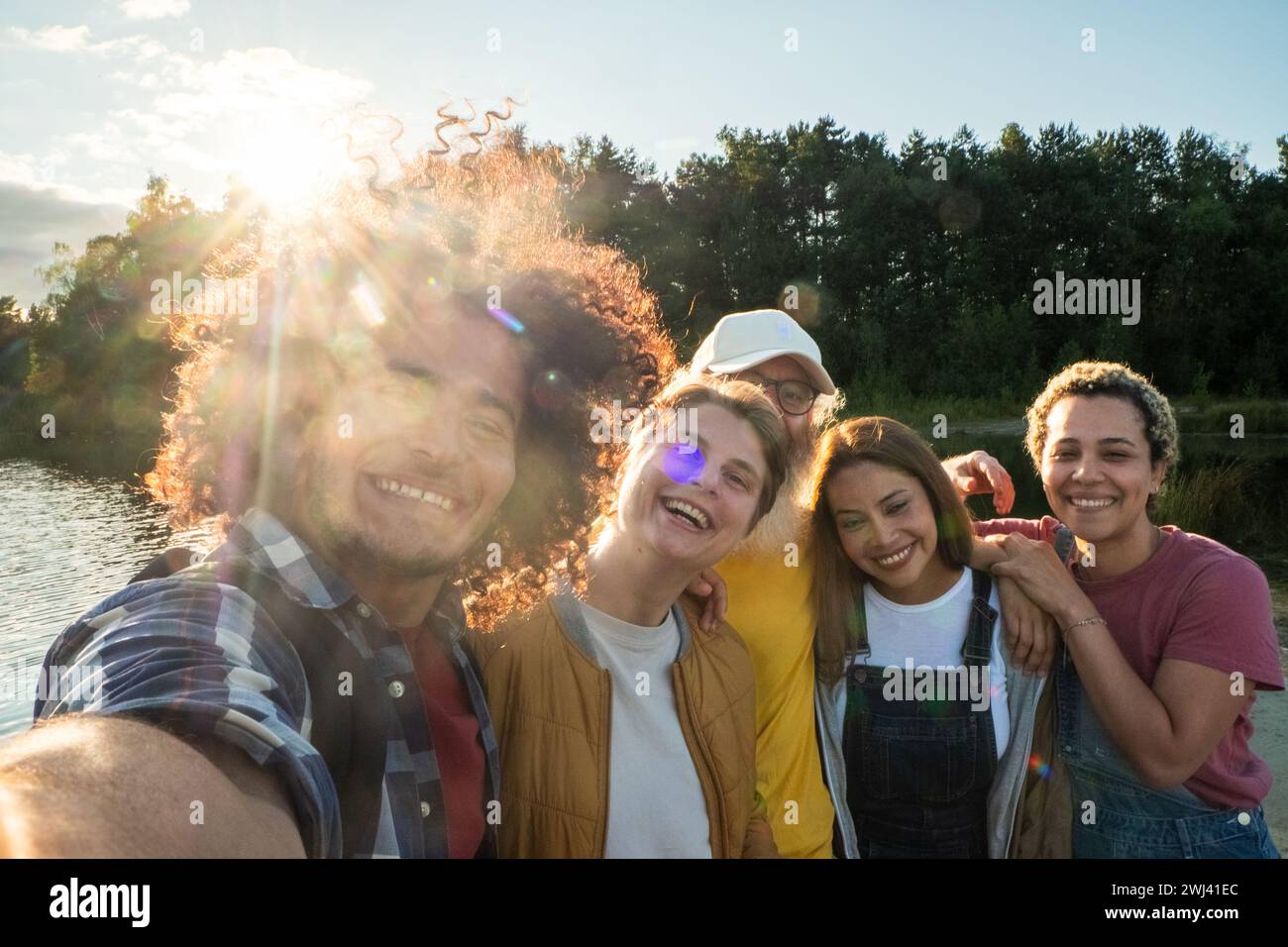 Sunshine Selfie: A Group's Moment of Joy by the Lake Stock Photo
