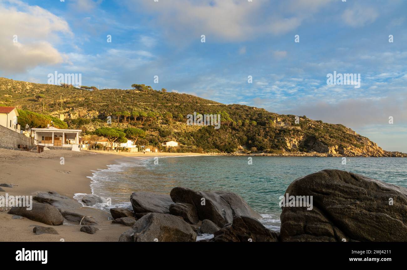 Landscape view of Cavoli Beach on Elba in warm evening light and boulders in the foreground Stock Photo