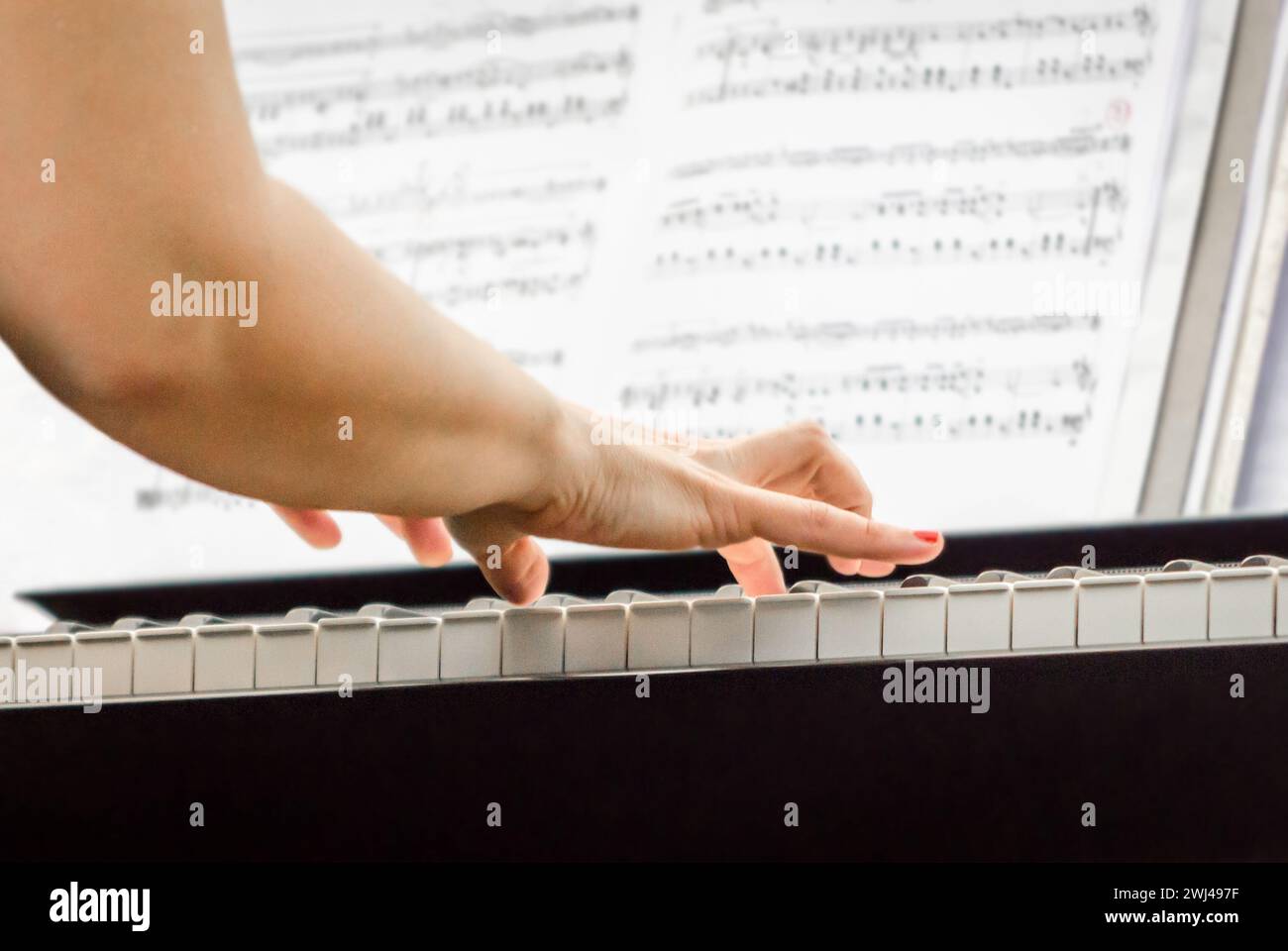 Female hands of a pianist musician and piano keys close up Stock Photo
