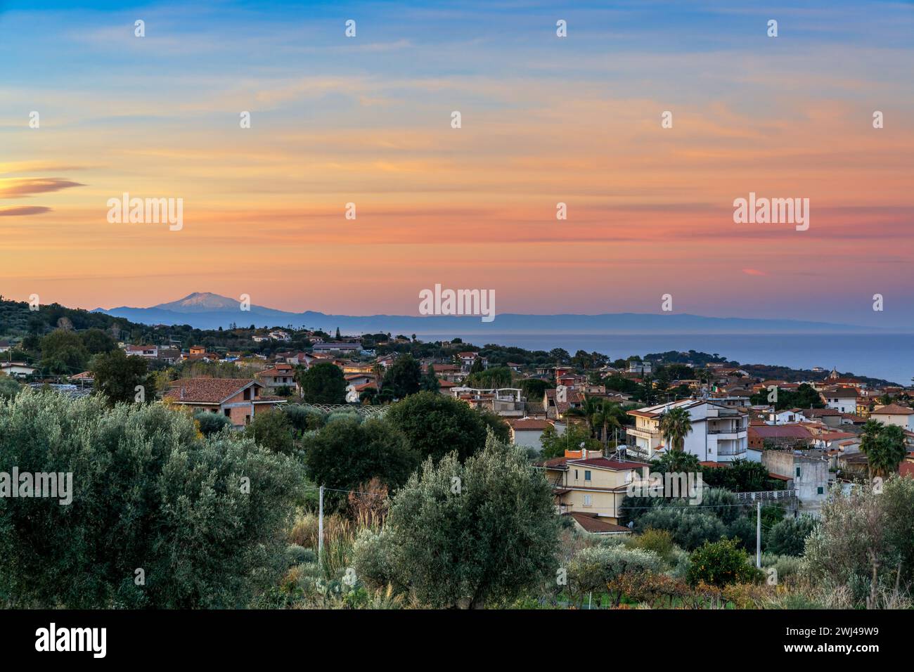 View of the village of Ricadi in Calabria at sunrise with Sicily and Mount Etna in the background Stock Photo