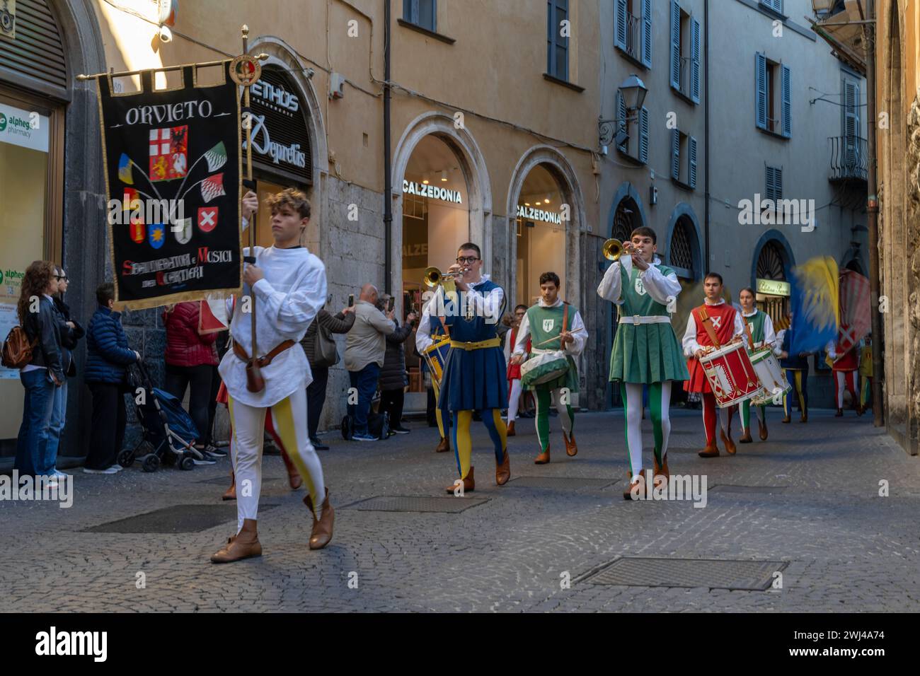 Marching band dressed in medieval clothes marching through the streets of old town Orvieto Stock Photo