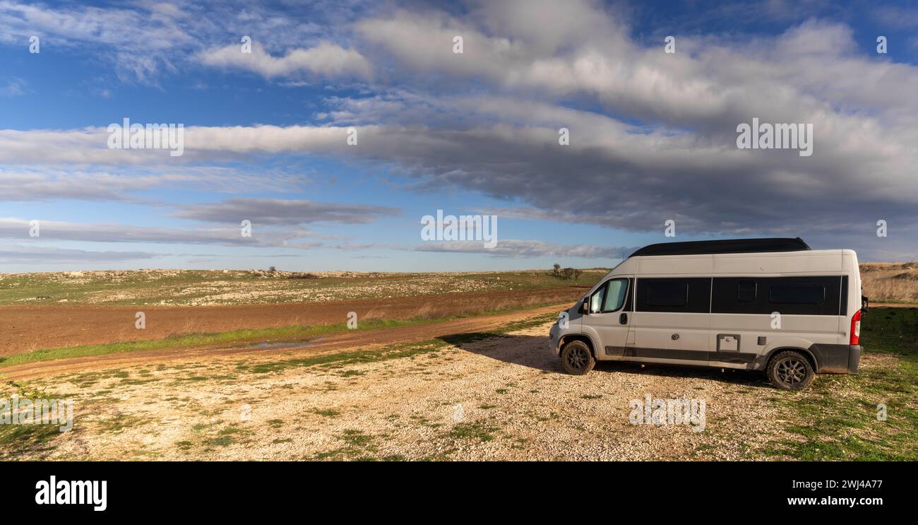 Gray camper van parked in the middle of nowhere in the Alto Murgia Naitonal Park in Italy Stock Photo