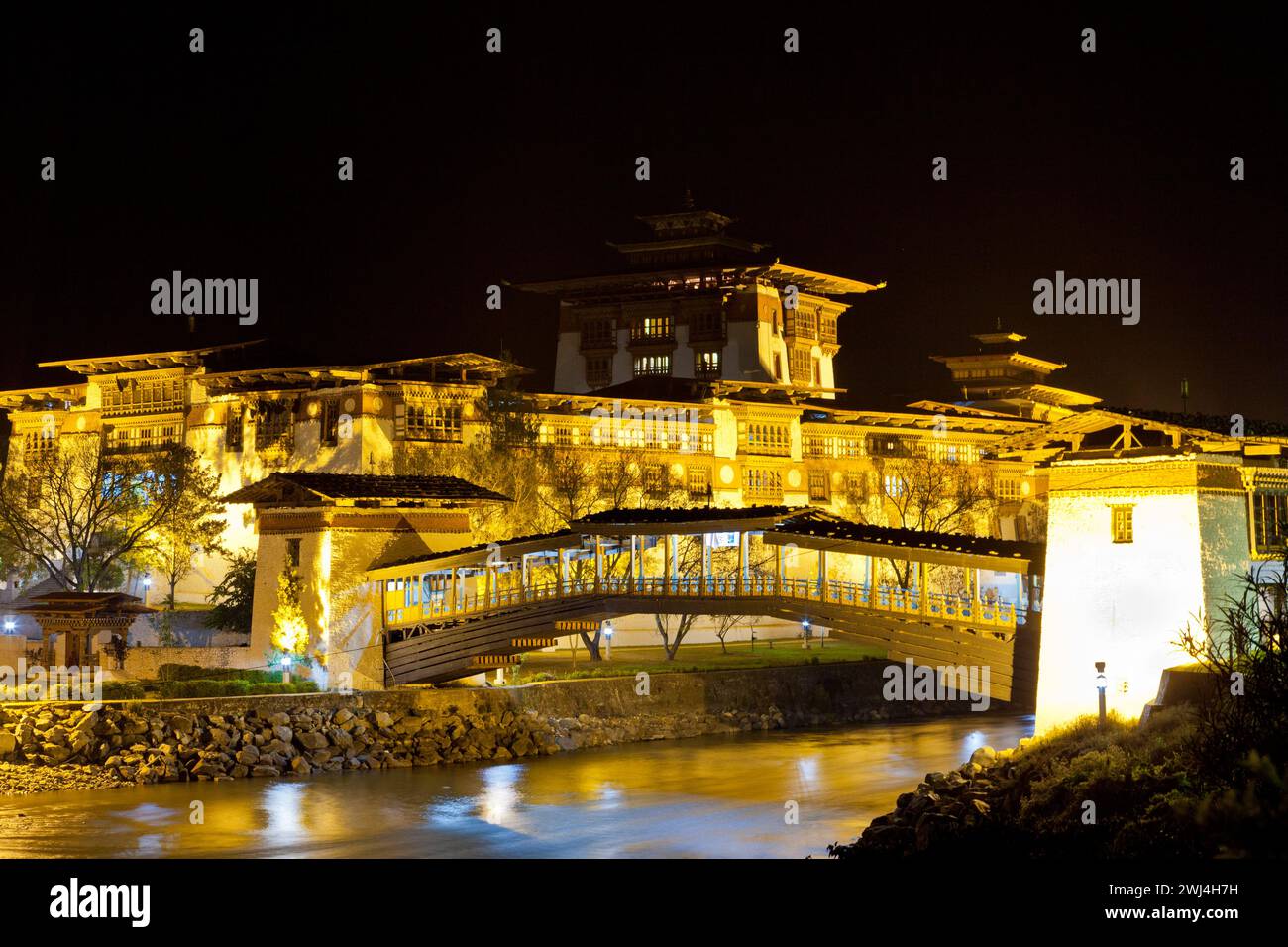 Punakha Dzong with traditional cantilever bridge spotlit at night Stock ...