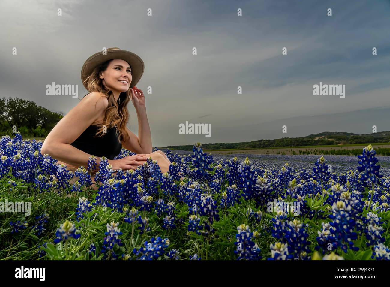 A Lovely Brunette Model Poses In A Field Of Bluebonnet Flowers In A Texas Prarie Stock Photo