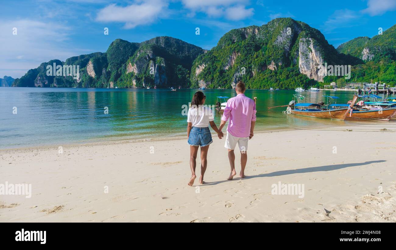 A couple of men and woman at Kho Phi Phi Thailand walking on the beach in the morning Stock Photo